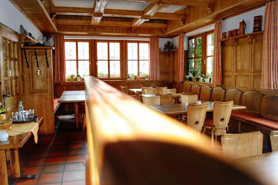 Helle Gaststube mit Sonnenlicht durch die Panoramafenster